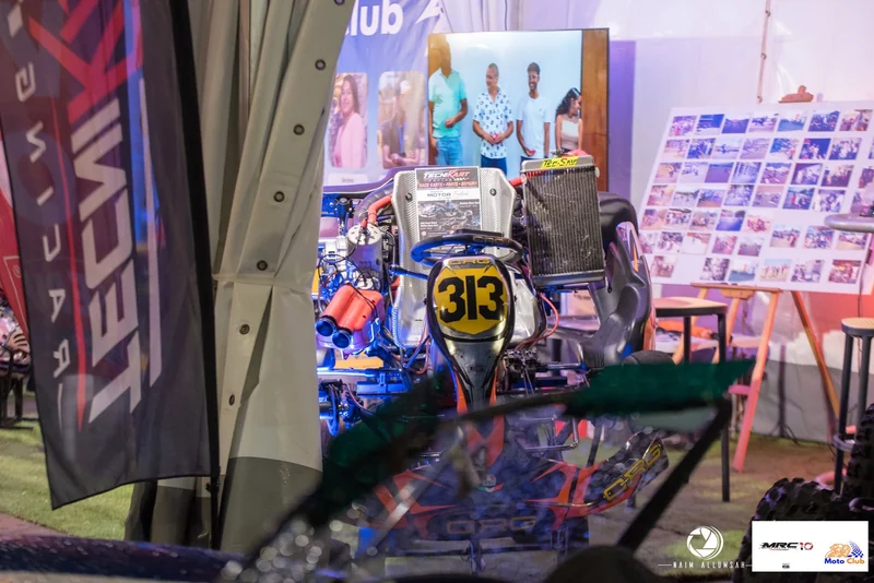 Kart 313 on display beside an easel of older karting photographs.