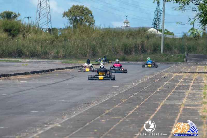 Several karts moving away along the outdoor course at Anjalay.